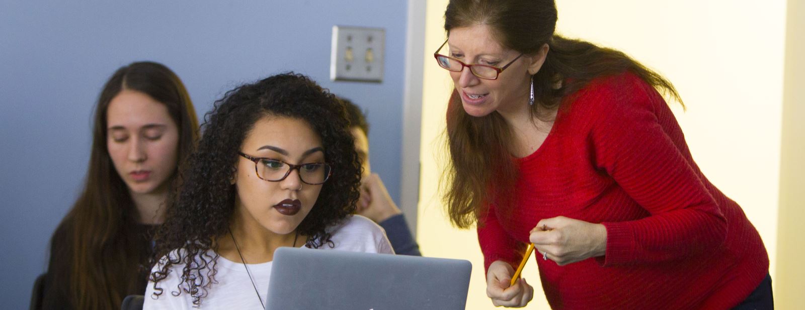 Professor working with students in a classroom 